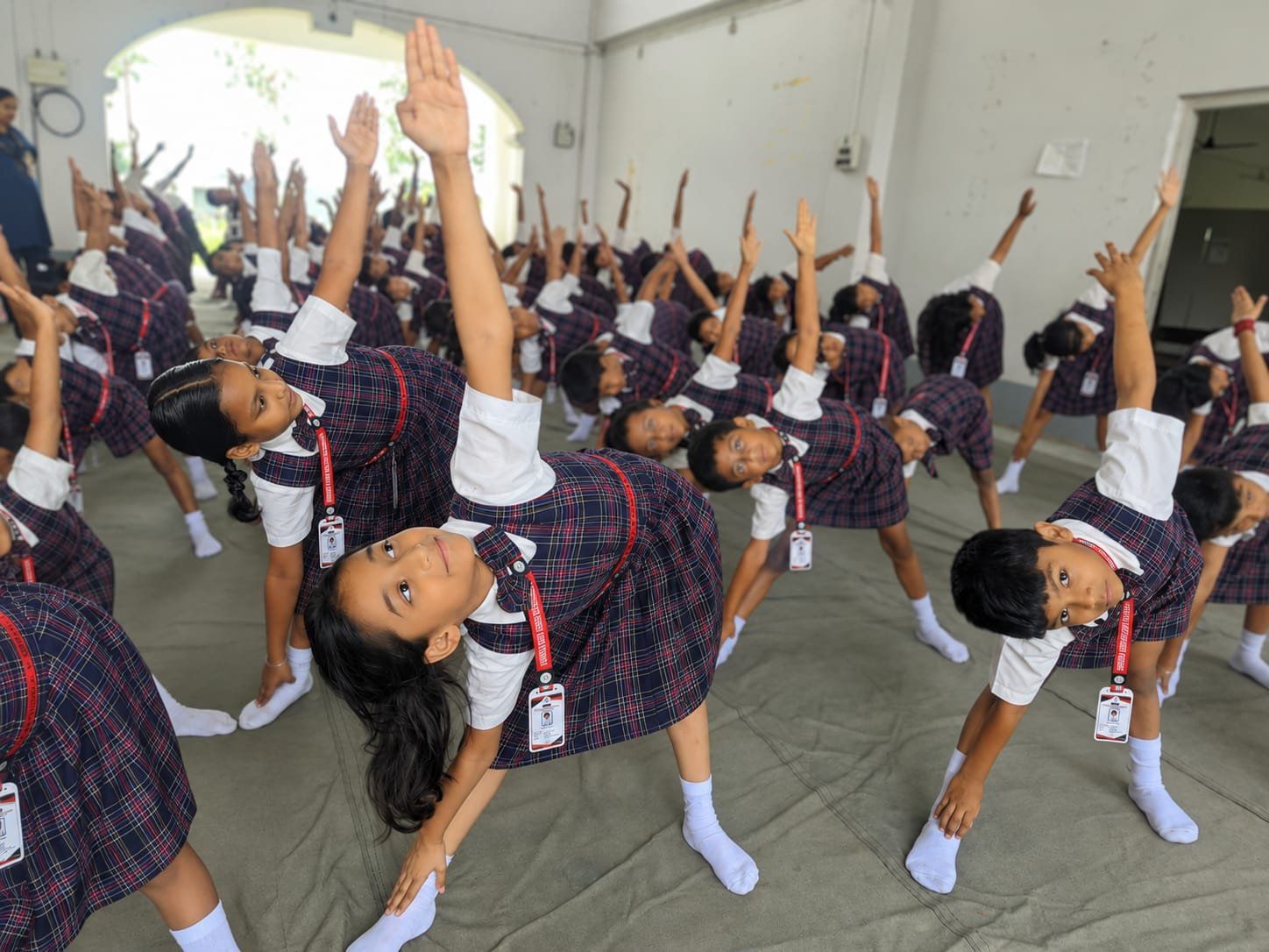 A class of IGPS students doing a yoga stretch together